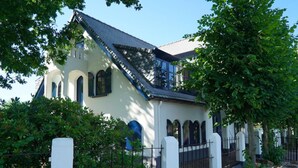 A building with a sloped roof, arched windows, and a white facade. - Holiday Home in Hulshorst With Terrace (Hulshorst)