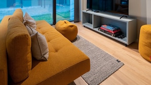 Un salon moderne avec un grand téléviseur à écran plat, un canapé et une table basse.