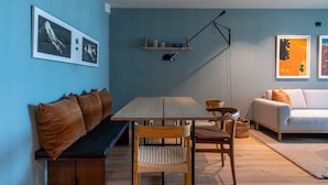 Un salon avec une table en bois, un banc, un canapé et une lampe sur pied.