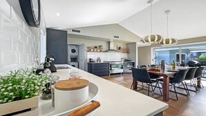 Een moderne keuken met een centraal eiland, inbouwapparatuur en een eetgedeelte met uitzicht.