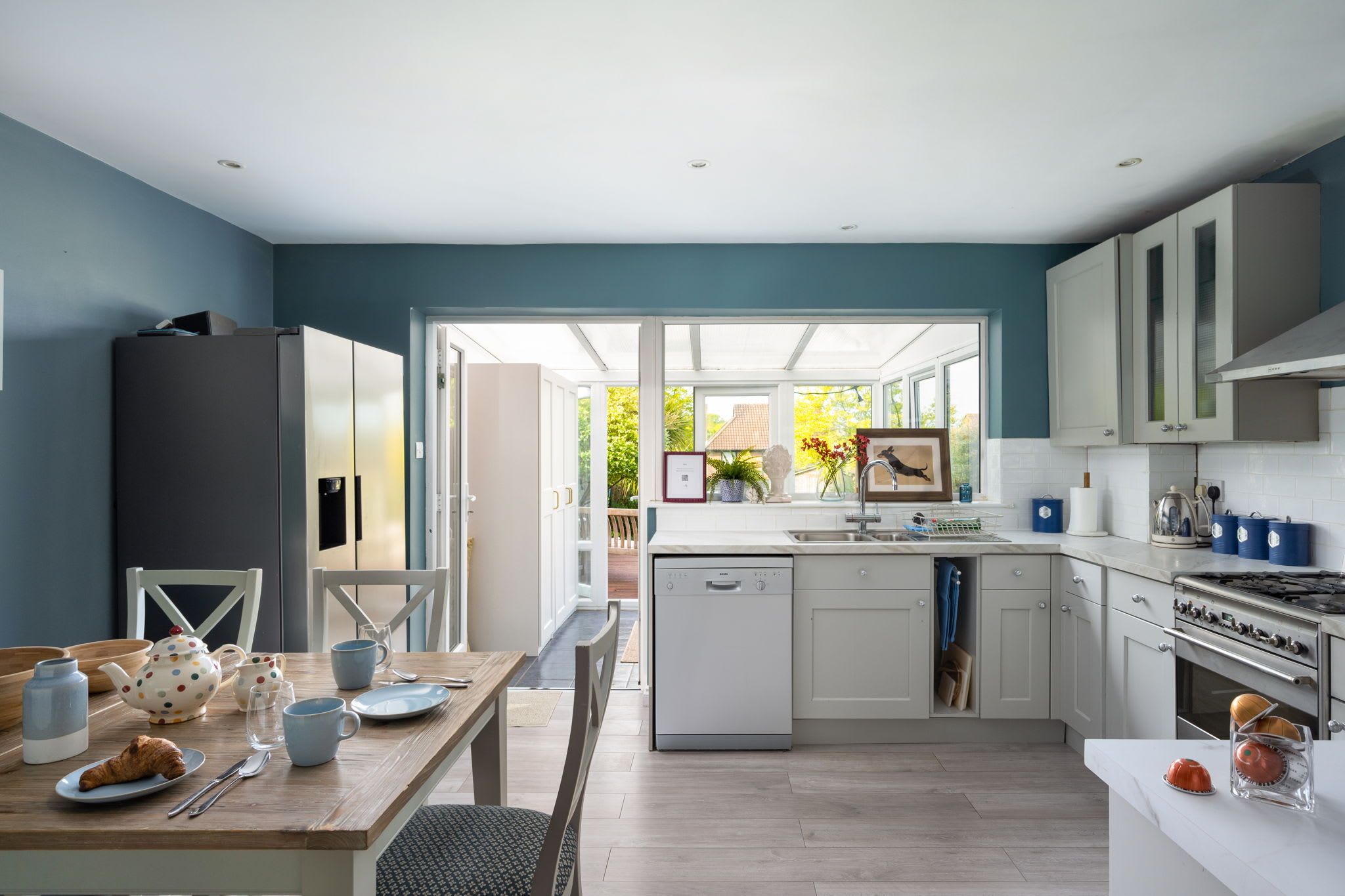 A modern kitchen with a dishwasher, stove, and a dining area with a table set for two.