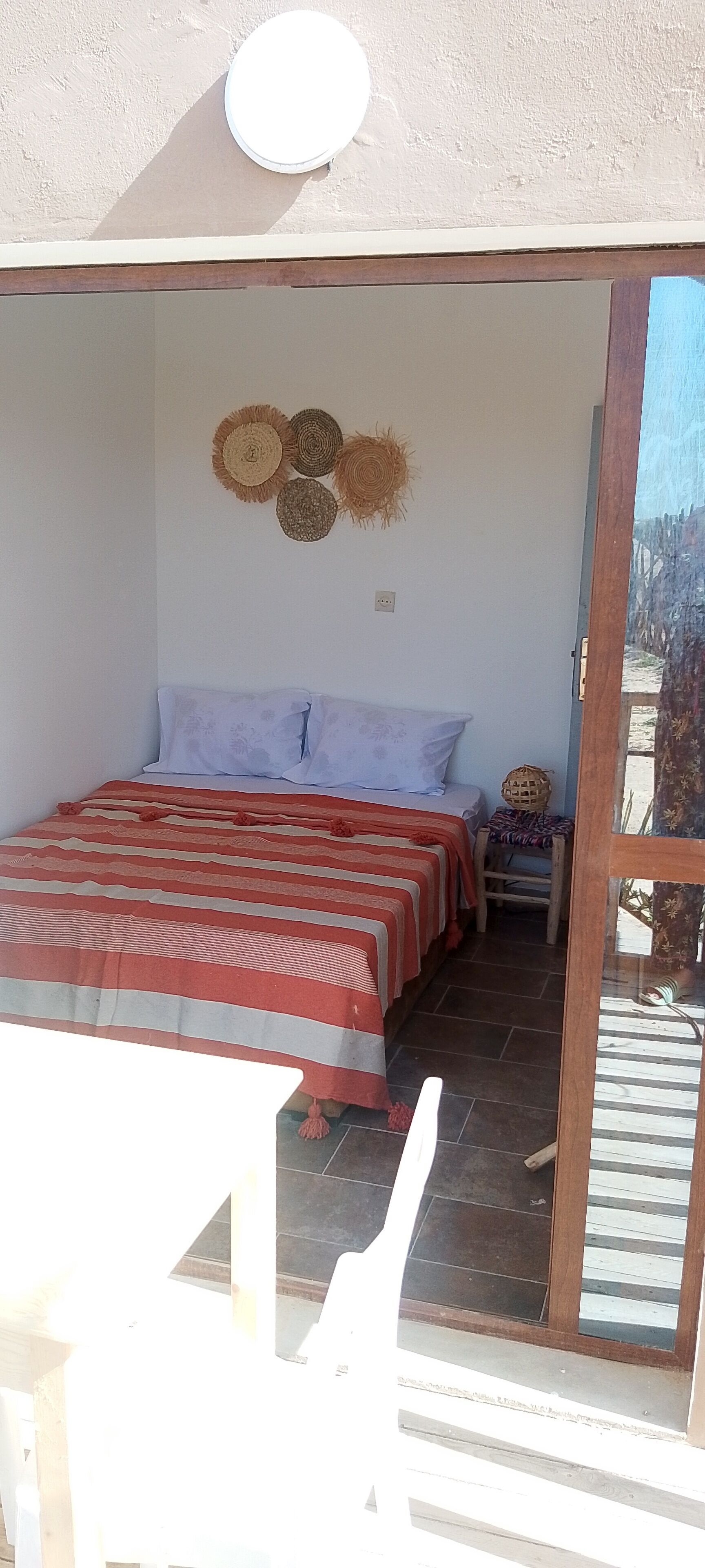 Un dormitorio con una cama, una mesita y una silla.