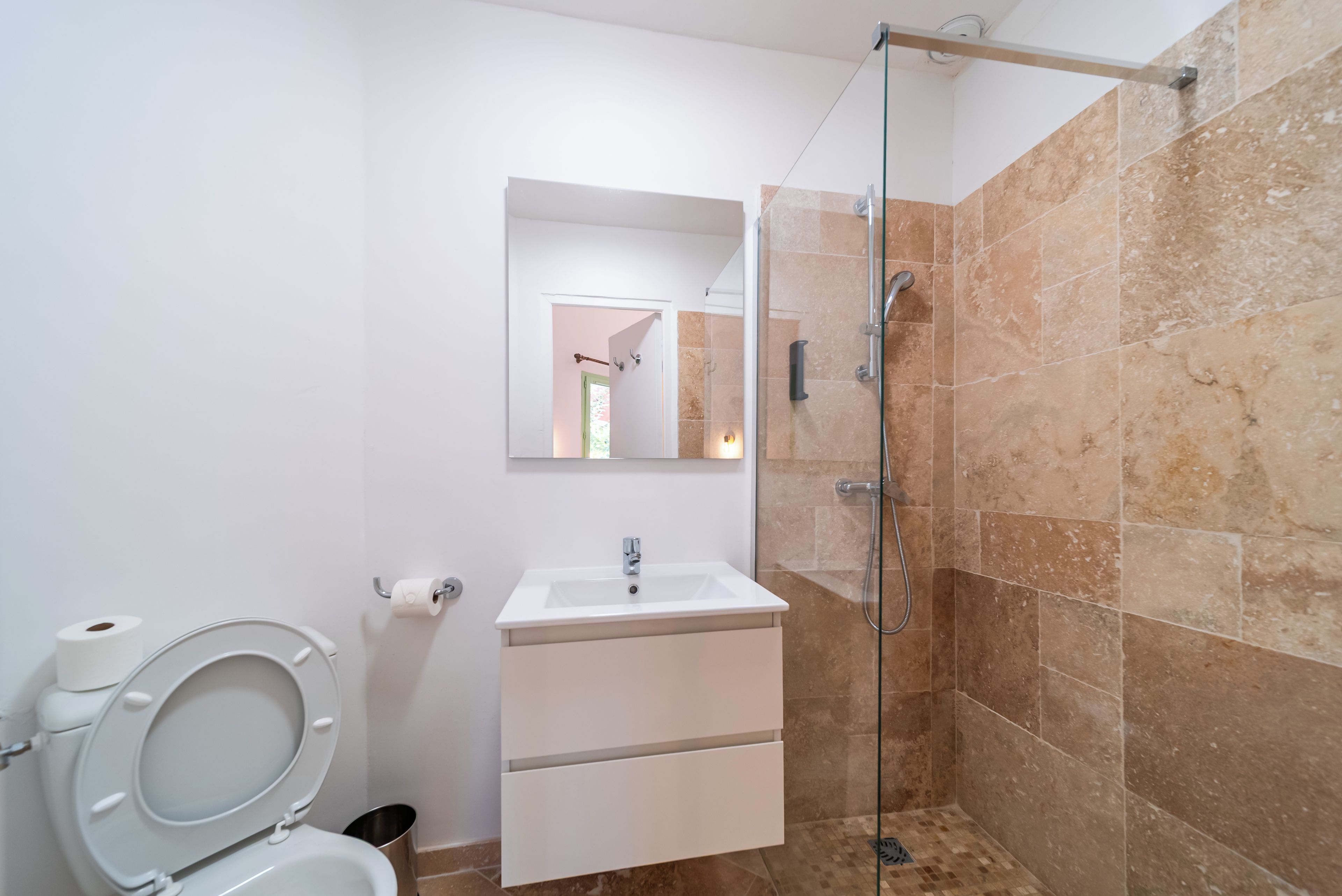 Un baño con inodoro, lavamanos y ducha.