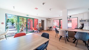 Un interior moderno con una mesa de madera, sillas y un separador de vidrio.