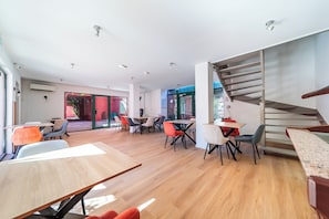Decoração moderna com escada, várias mesas e cadeiras.