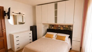 A bedroom with a bed, a dresser, a wardrobe, a mirror, and a wall-mounted light fixture. - Martina's House (Villanova di Camposampiero)