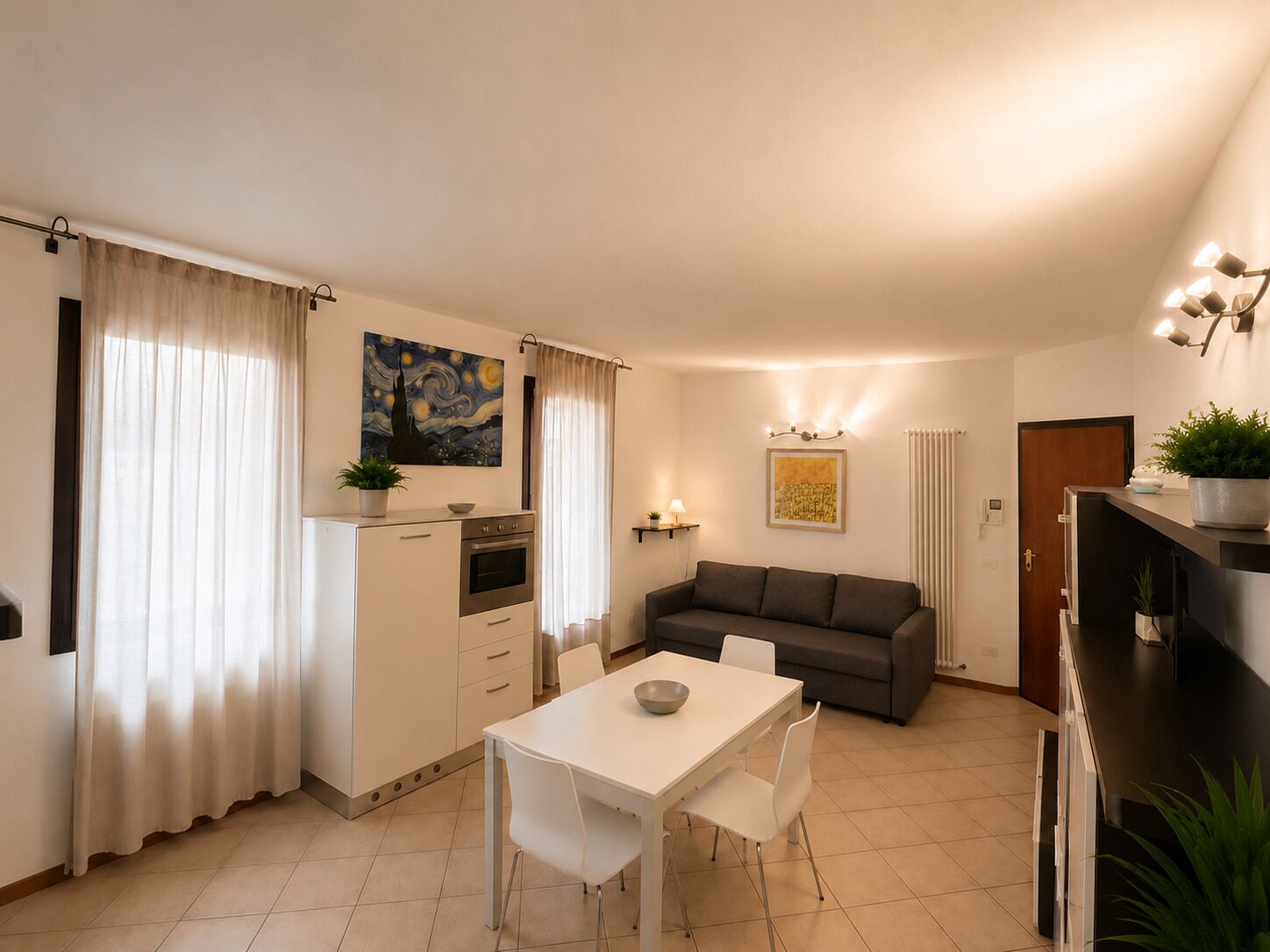A compact living space with a kitchenette, dining area, and a sofa.