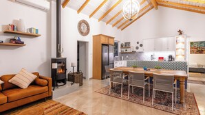 Una sala de estar acogedora con chimenea, un comedor con mesa y sillas, y una cocina equipada con electrodomésticos modernos.