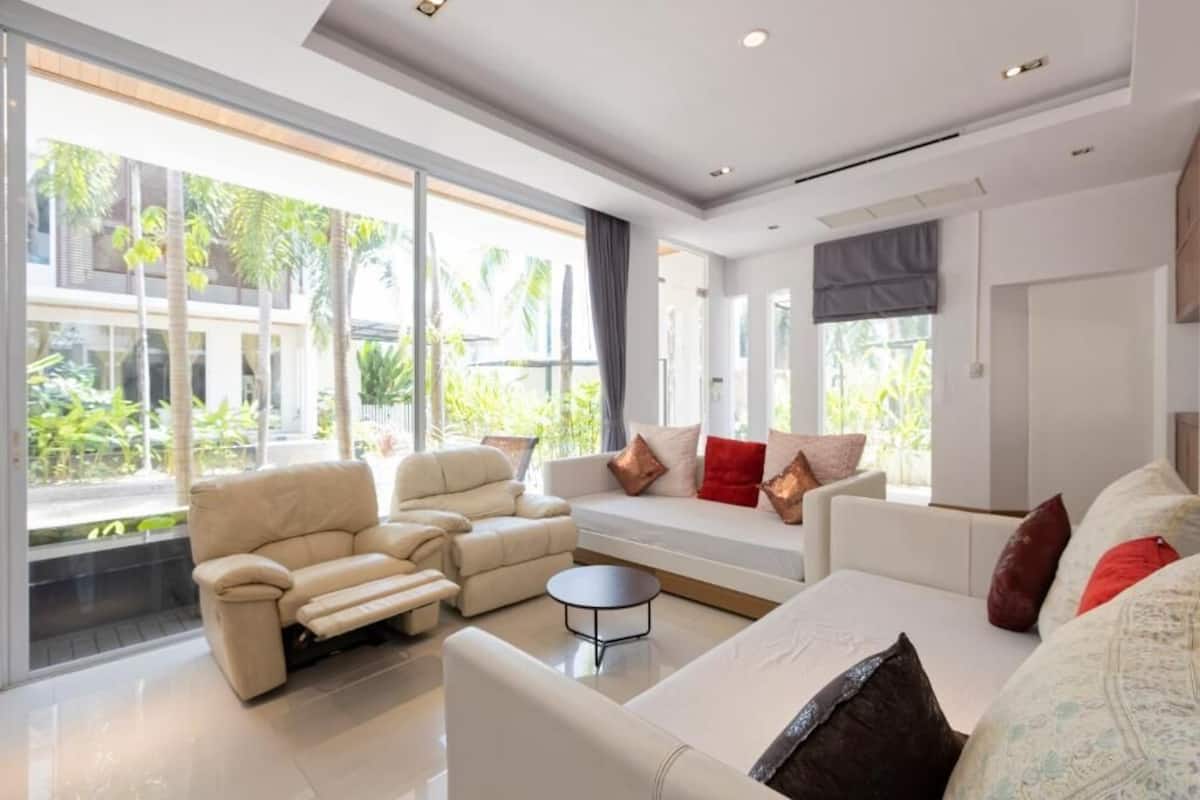 A modern living room with a sofa, armchairs, and a coffee table.