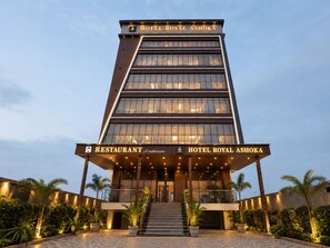 Un hotel de varios pisos con una entrada destacada y el letrero de un restaurante.