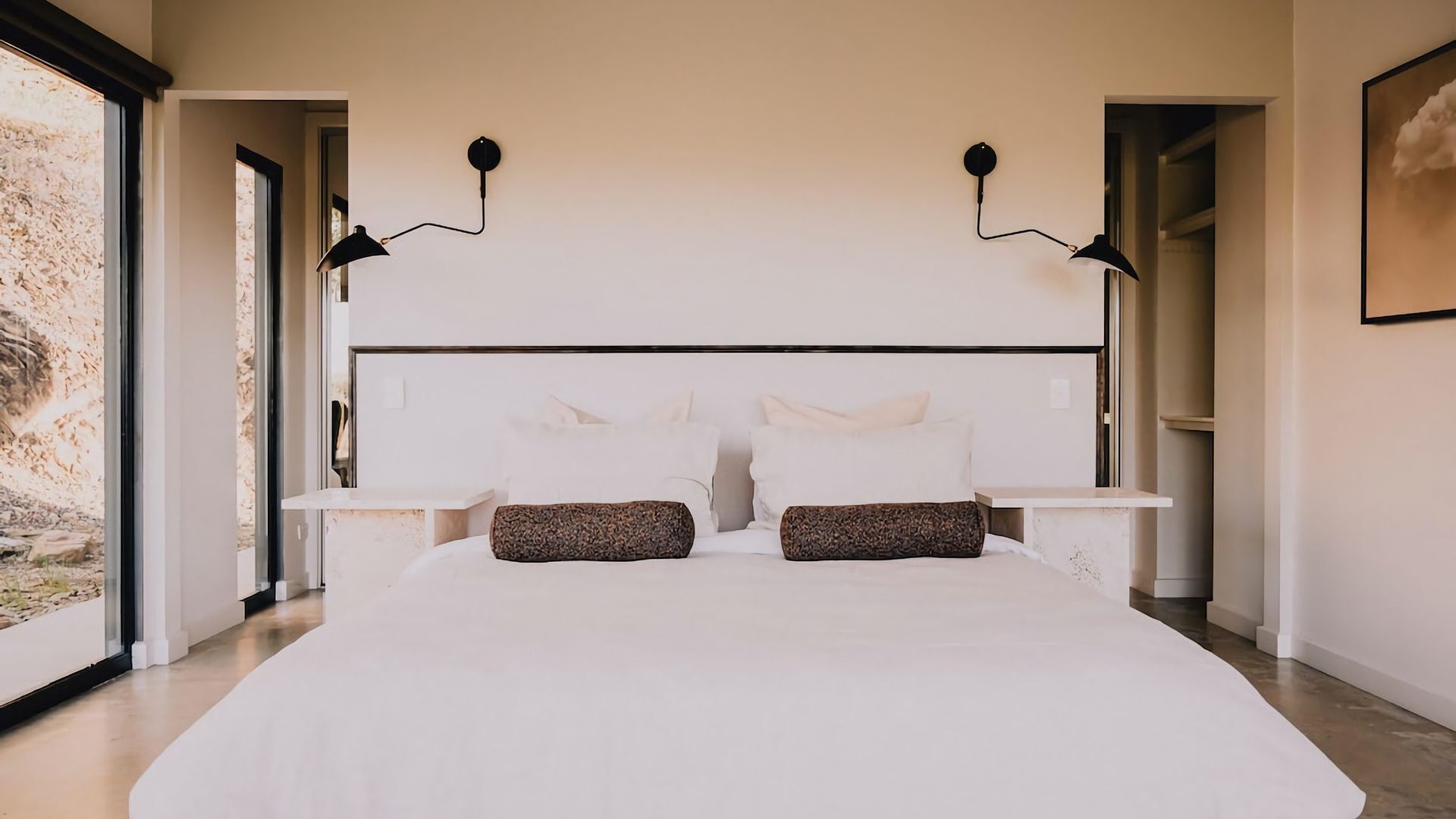 A bedroom with a large bed, two bedside tables, and a headboard.