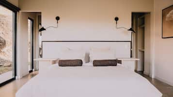 A bedroom with a large bed, two bedside tables, and a headboard.