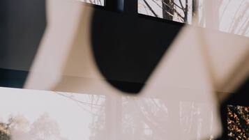 Une pièce dotée d’une grande fenêtre, d’un lit et offrant une vue partielle sur un mur.