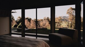A bedroom with a large window, a bed, and a chair. - Echo 1 Bedroom - couples retreat (Buffalo River)