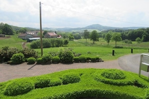 A rural landscape with a paved path, neatly trimmed hedges, and distant houses. - Öttersbach The Little (Poppenhausen)