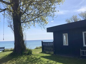 A house with a view of the sea, a tree, and a bench. - 4 Star Holiday Home in Rodvig Stevns (Rodvig Stevns)