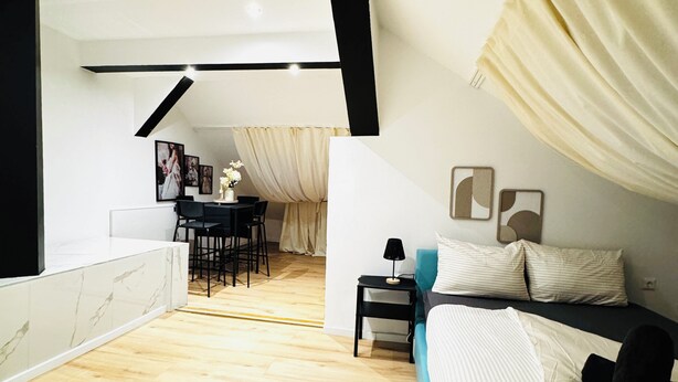 Une chambre moderne avec un lit, un bureau et un coin repas.