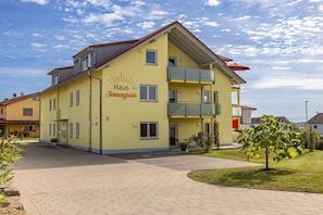Ein gelbes Gebäude mit Balkonen und einem Schild, auf dem 'Haus Sonnengross' steht.
