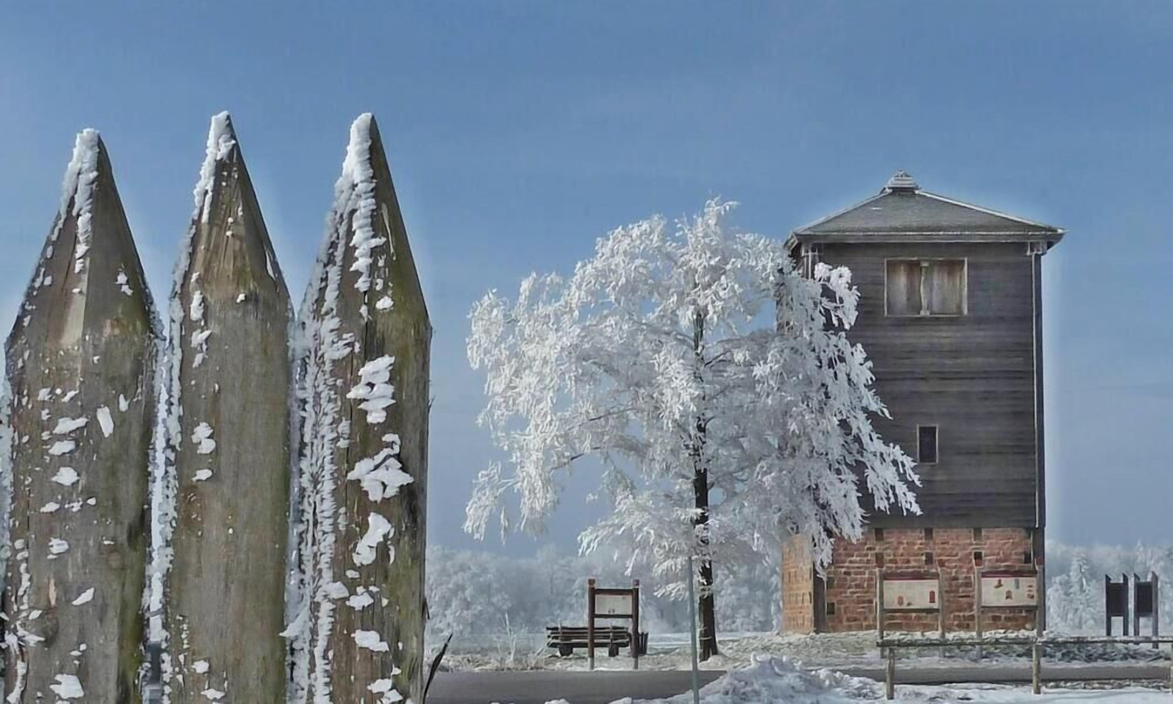 Paisaje nevado con una estructura de madera y un banco.