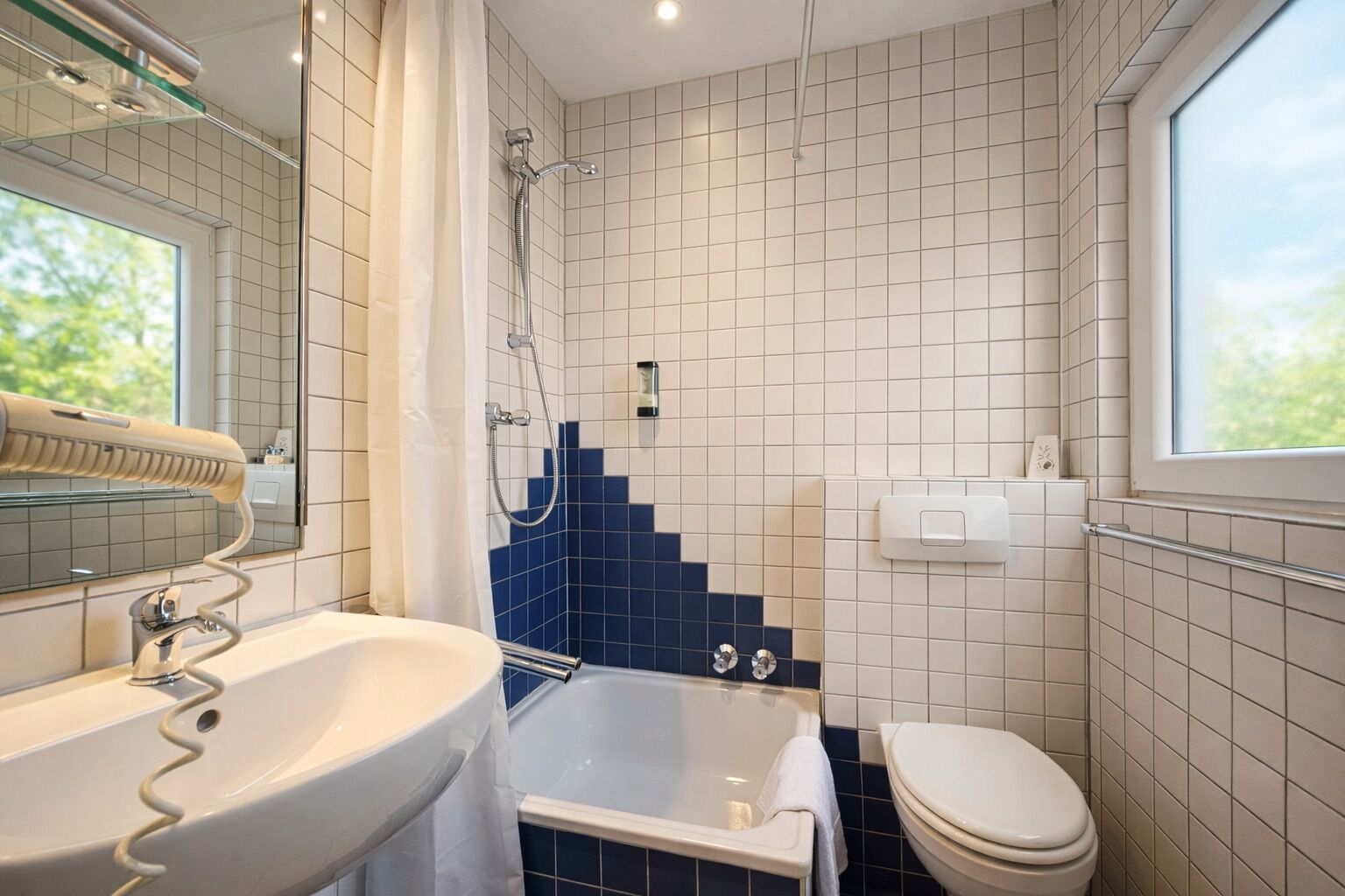 Tweepersoonskamer | Badkamer | Een haardroger, handdoeken, zeep, shampoo