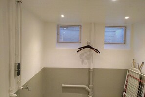 Ein Badezimmer mit zwei Fenstern, einem Handtuchhalter und einer Duschkabine.