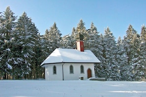 A small white church with a red steeple, surrounded by snow-covered trees. - Holiday apartment with 2 bedrooms (Rickenbach)