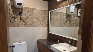 Een douche, handdoeken, zeep, toiletpapier