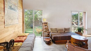 Ein modernes Interieur mit einer Holzwand, einem großen Fenster, einer Couch, einer Leiter und einer Lampe.