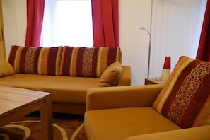 A living room with a sofa set, a coffee table, and a lamp. - Holiday apartment with 2 bedrooms (Walsrode)