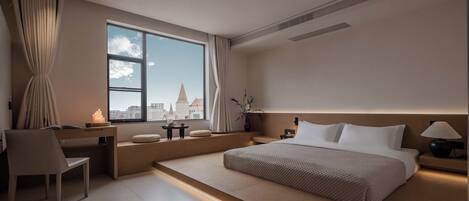 Una habitación de hotel moderna con un ventanal grande, un escritorio, una cama y una mesita de noche.