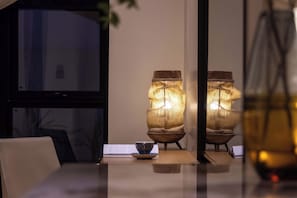 A dining table with a cup and saucer, a lamp, and a window. - Silver Beach Puyue Designer Homestay (Beihai)