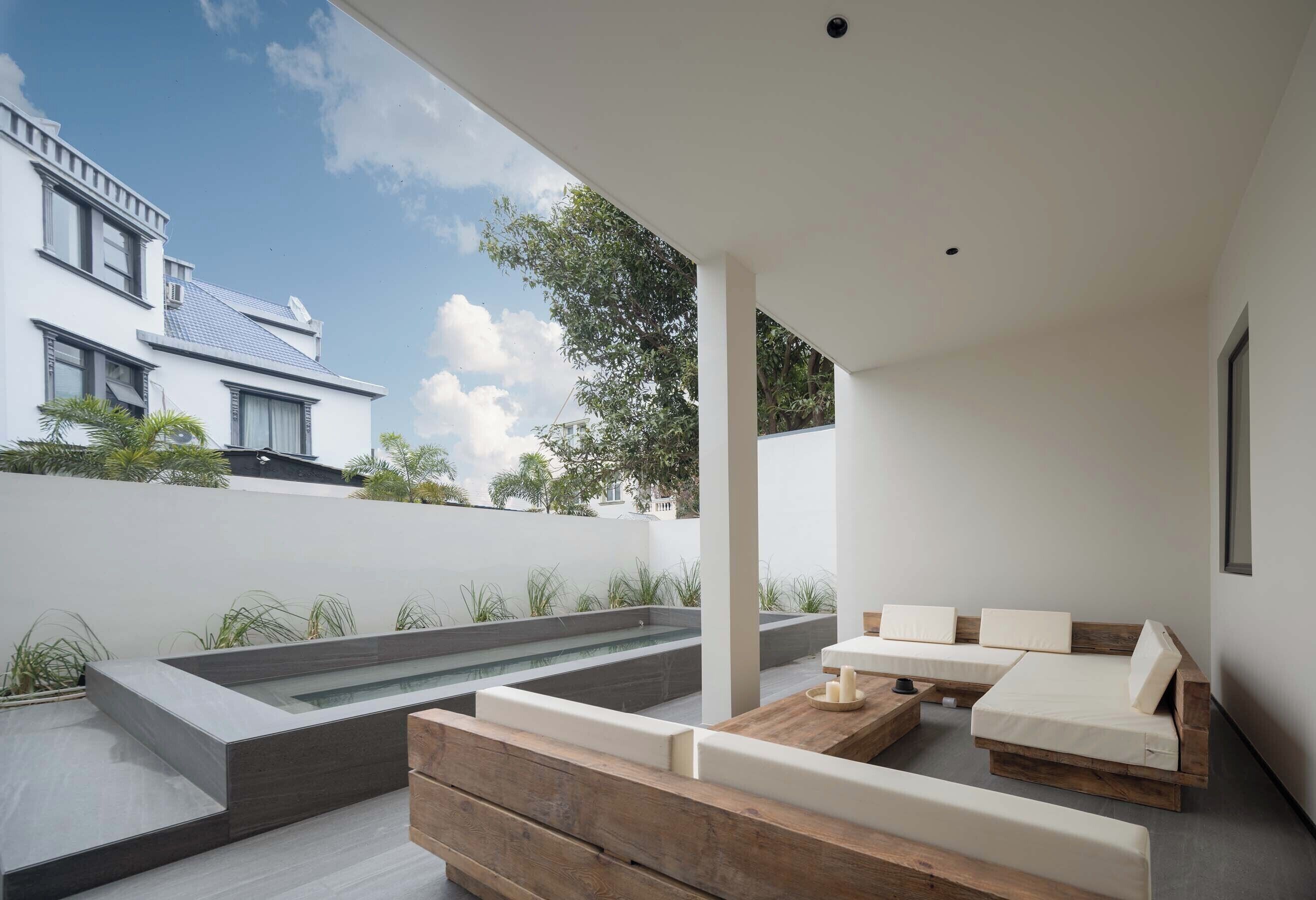 A modern outdoor seating area with built-in benches and a rectangular water feature.