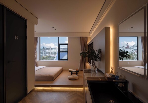 A modern bedroom with a bed, bedside table, and a large window with a city view.