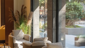 Un interior moderno con una zona de estar, ventanas amplias y vistas al exterior.