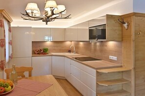 Eine moderne Küche mit einer gewölbten Arbeitsplatte, einem eingebauten Herd und einer Wand mit Holzvertäfelung.