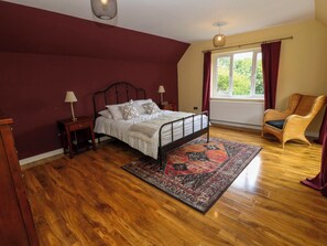 A bedroom with a bed, bedside lamps, a window with curtains, a chair, and a patterned rug. - 331 Coniscliffe Road (Darlington)