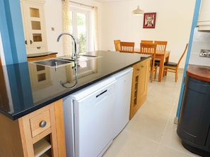 A kitchen with a dishwasher, a sink, and wooden cabinets. - 331 Coniscliffe Road (Darlington)