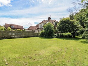 A residential area with a grassy yard, a wooden fence, and houses with pitched roofs. - 331 Coniscliffe Road (Darlington)