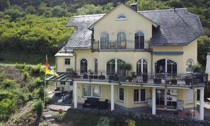 A two-story house with a balcony, large windows, and a flag. - Holiday apartment in Kestert with Wi-Fi (Kestert)