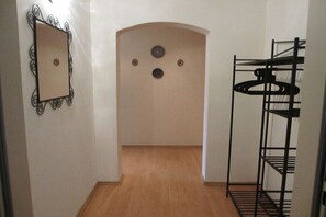 Un corridoio con uno specchio, un attaccapanni e una porta decorata con tre motivi circolari.