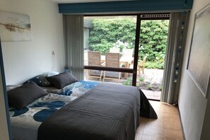 Ein Schlafzimmer mit einem Bett, einem Fenster und Blick ins Freie.