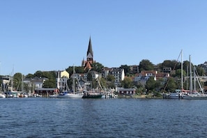 Ein Hafen mit Booten, einer Kirche und Wohnhäusern.
