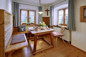 Um quarto acolhedor com uma mesa de madeira, um banco e uma cadeira.