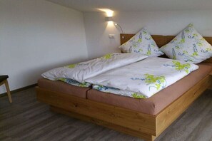 Ein Einzelbett mit Holzrahmen, Kopfteil und einer Wandlampe.