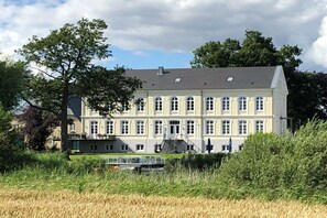 Ein großes, mehrgeschossiges Gebäude mit einer symmetrischen Fassade, zahlreichen Fenstern und einem zentralen Eingang.