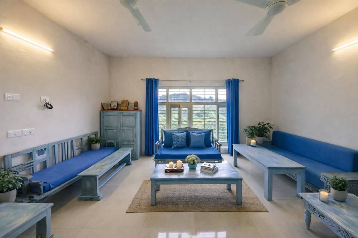 A room with a blue sofa, a coffee table, and benches along the walls.