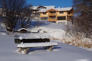 Eine Holzhütte mit Balkon, umgeben von verschneiter Landschaft.
