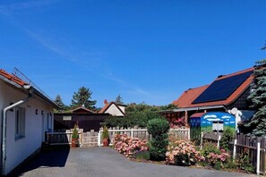 Een woonwijk met een verharde oprit, houten schermen en zonnepanelen op de daken.