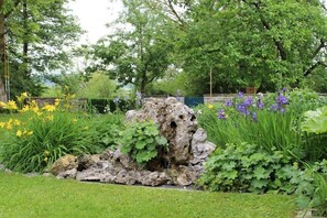 Ein Garten mit Felsformation, gelben und violetten Blumen.