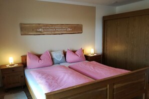 Ein Schlafzimmer mit einem hölzernen Bett, zwei Nachttischen mit Lampen, einem Holzschrank und einem an der Wand befestigten Schild.